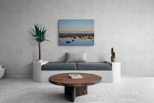 Modern living room with a gray sofa, wooden coffee table, and a large wall-mounted canvas print.